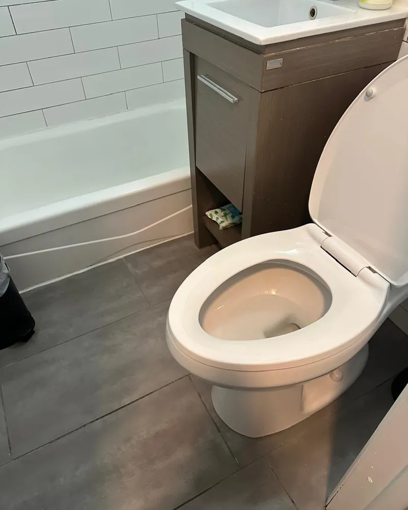 Baño pequeño con tina de azulejo tipo metro e inodoro limpio