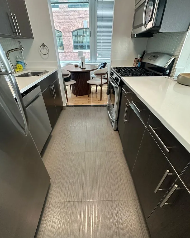 Cocina con cubiertas de cuarzo blanco impecables y electrodomésticos de acero