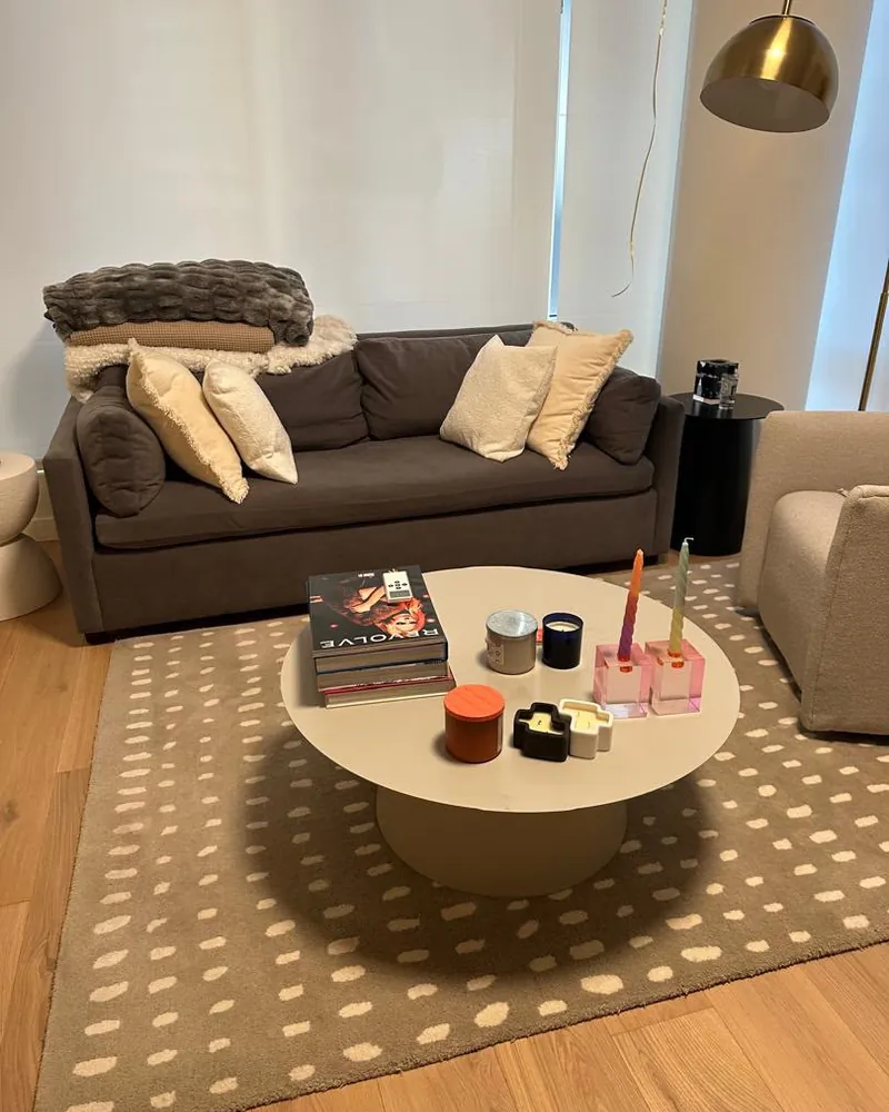 Sala limpia con sofá gris, mesa de centro decorada y tapete estampado